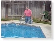 Person standing beside blue swimming pool with light-colored cover material on ground