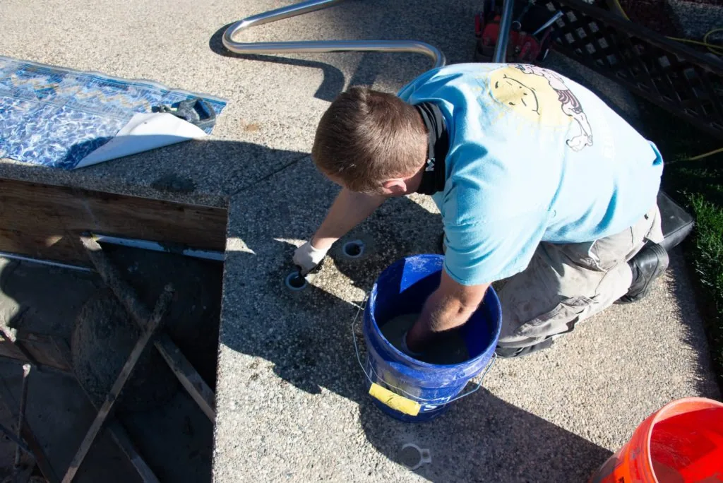 Child washing equipment with a hose and bucket outdoors on pavement