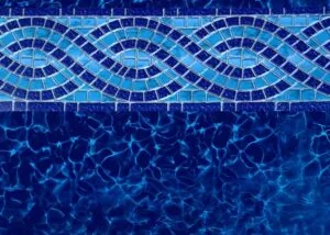 Blue mosaic tile border pattern above rippling swimming pool water