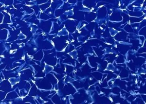 Bright neon blue light creating rippling patterns across water surface